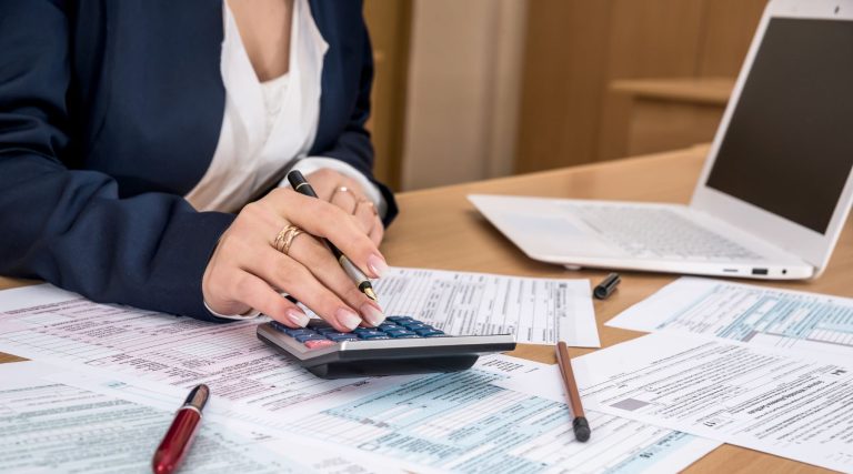 Businesswoman calculating taxes at her desk