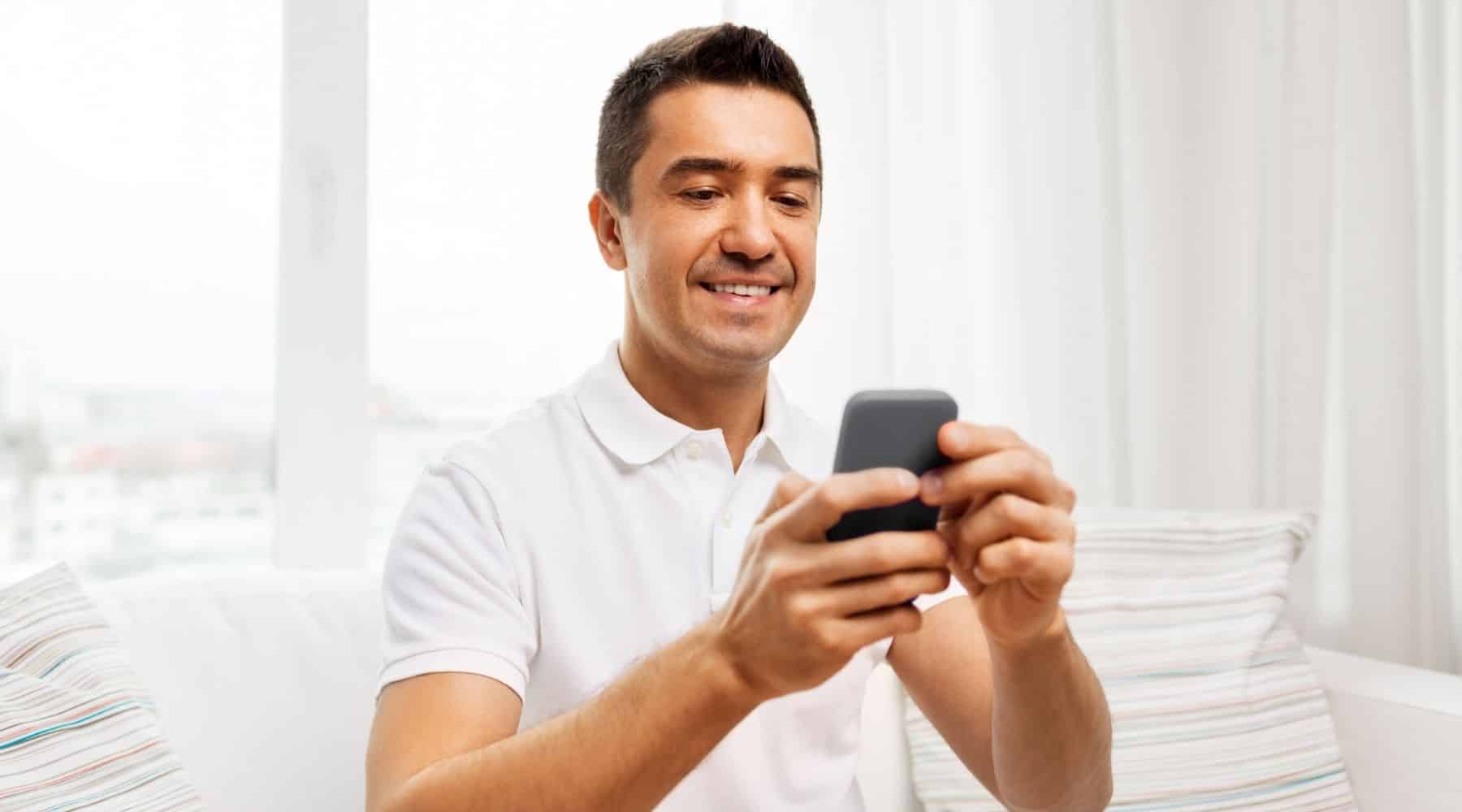 Man smiling while checking his phone