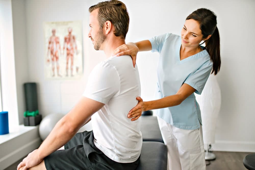 Physiotherapist with her hands on her client's back