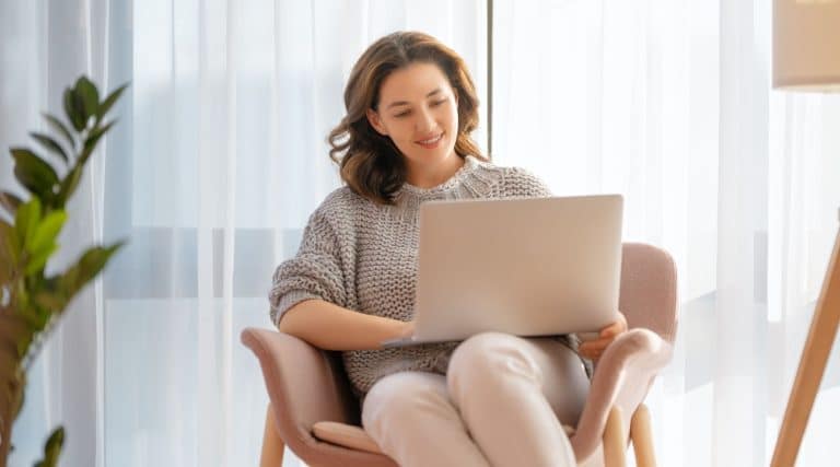Woman looking at her laptop in her living room