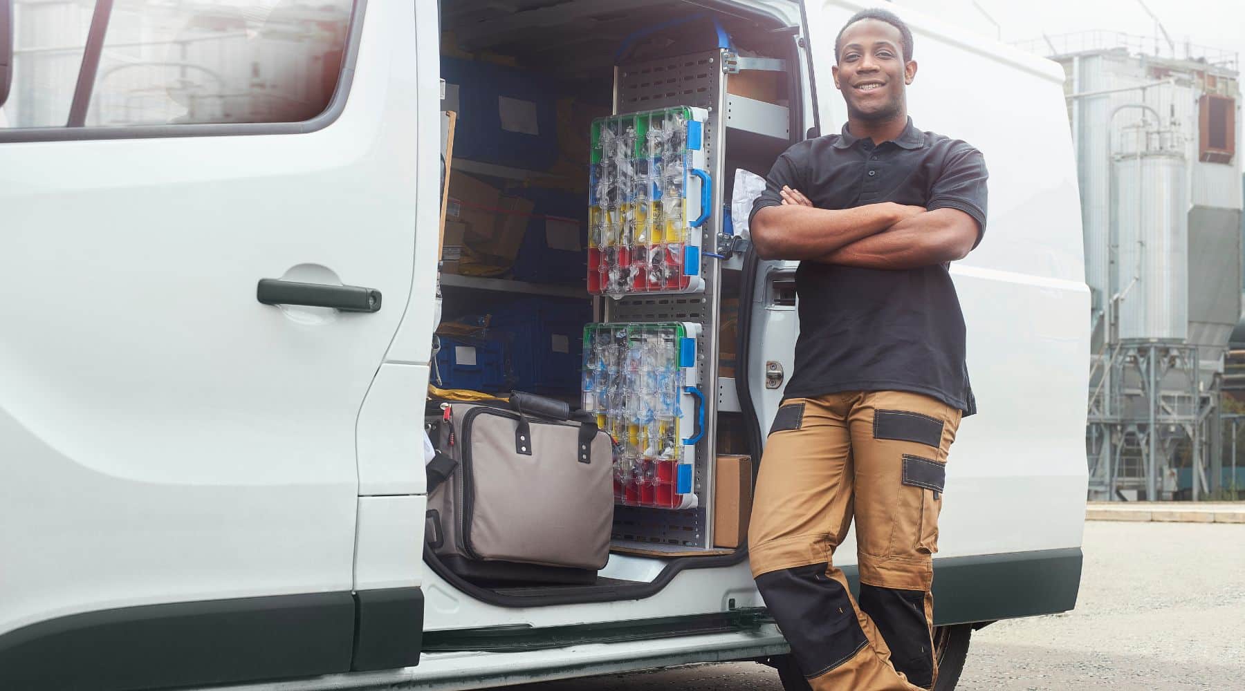 Tradesman smiling next to his van
