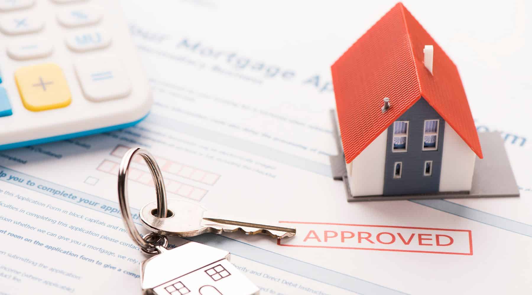 Model house and house keys on an aproved mortgage application form.