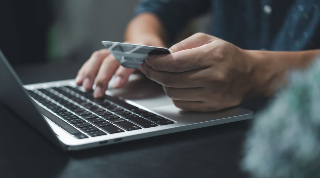 Person using debt card to buy something on their laptop