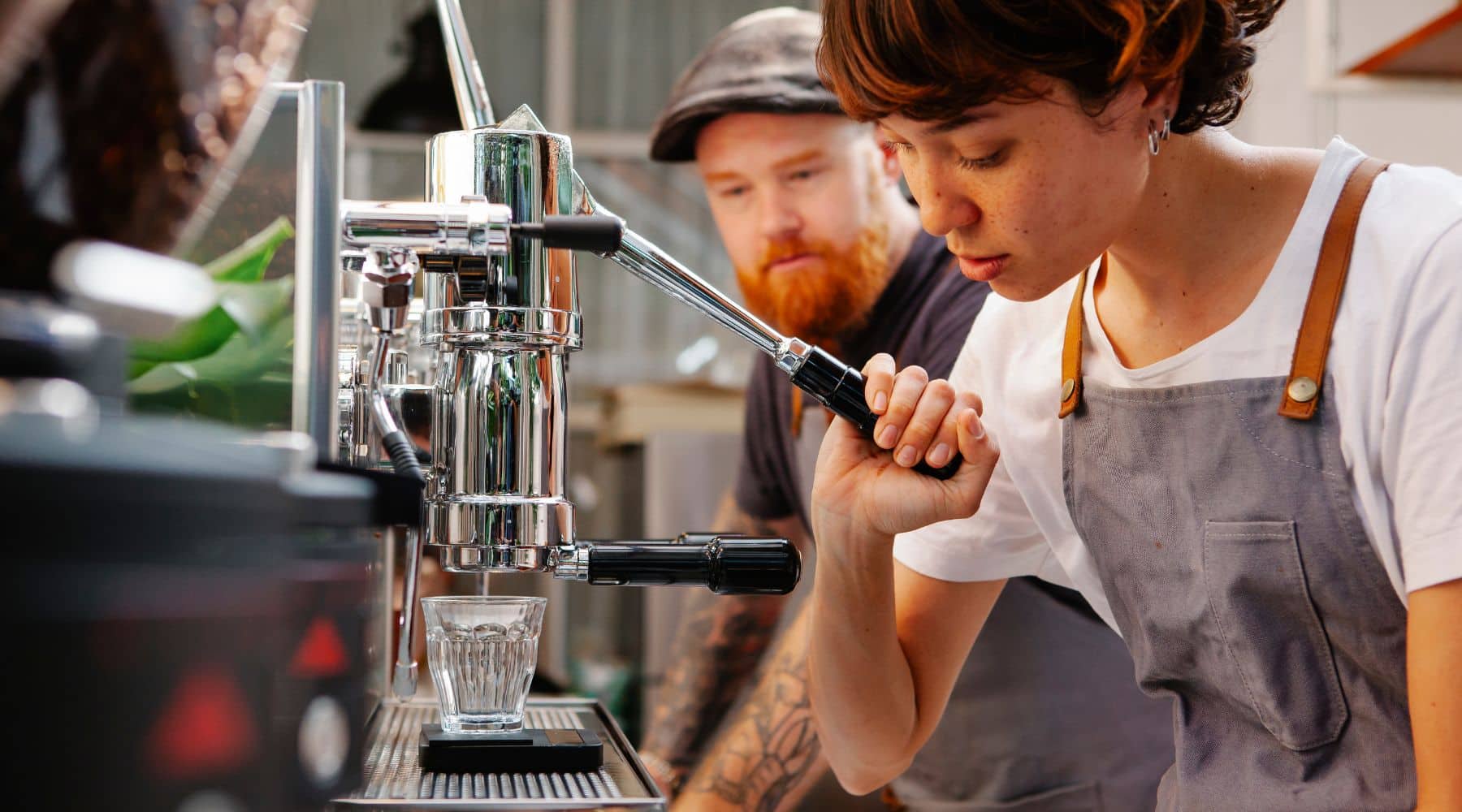 Barista making coffee using a commercial coffee machine.