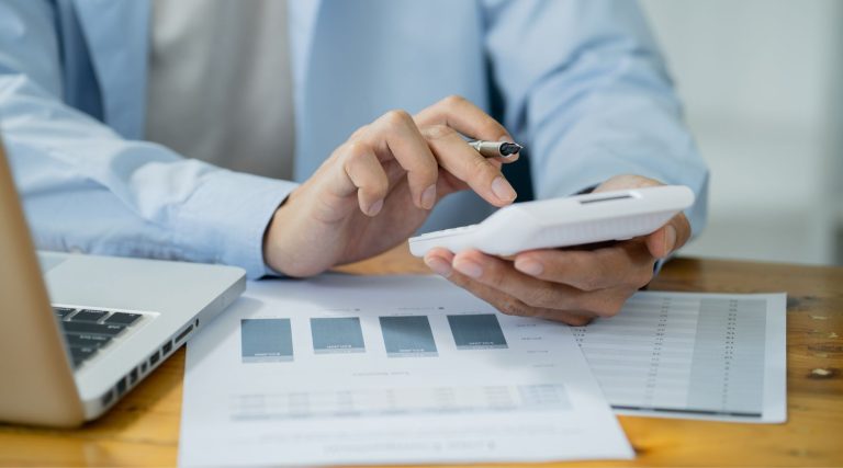 Businesswoman using a calculator at her desk