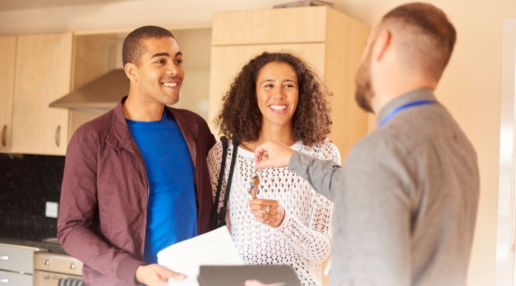 Happy tenants receiving the keys to their property