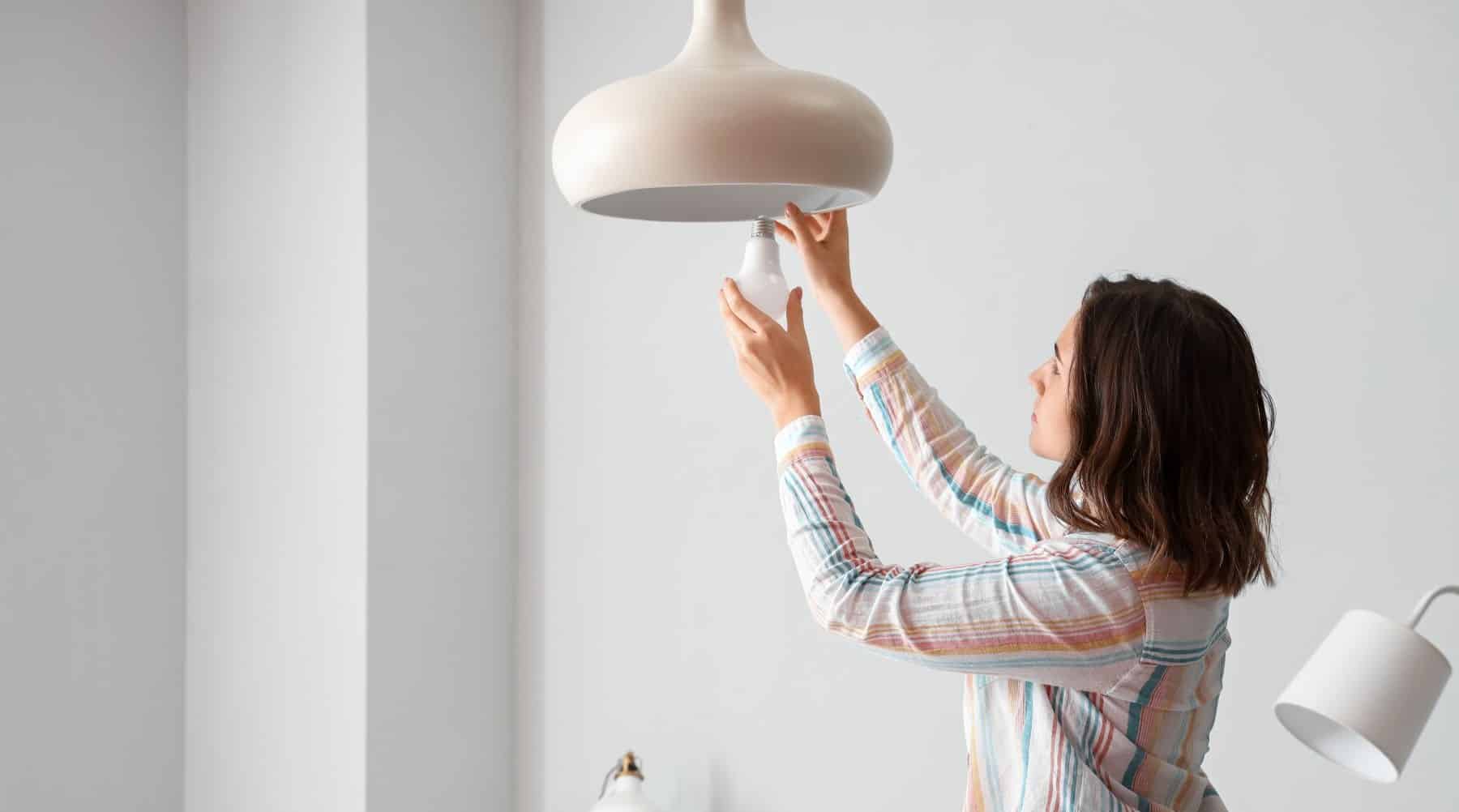 Woman changing a light bulb