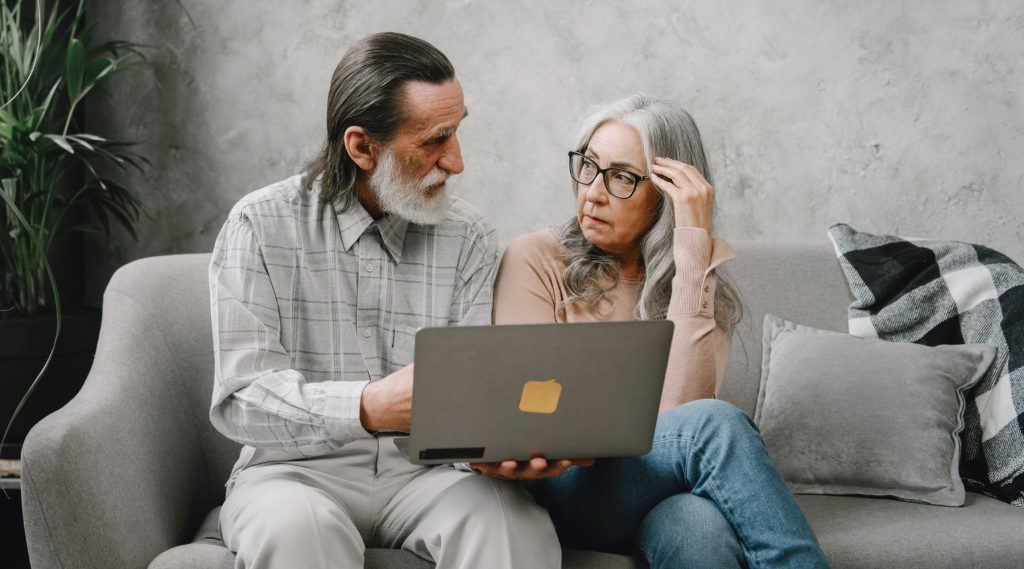 Older couple looking at laptop on the couch