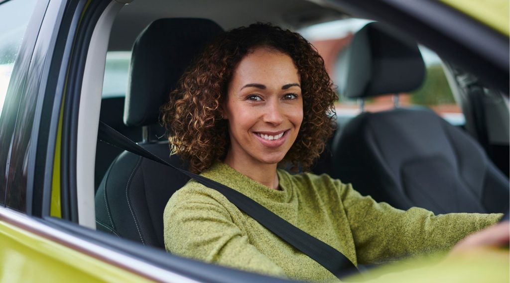 Smiling woman behind the wheel of her car