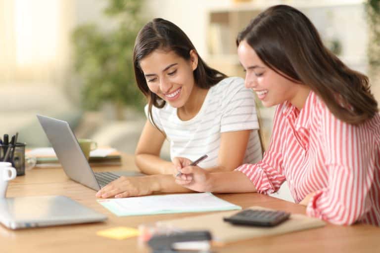 Two women signing a loan document