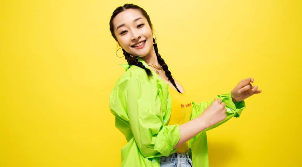 Woman dancing in front of yellow background