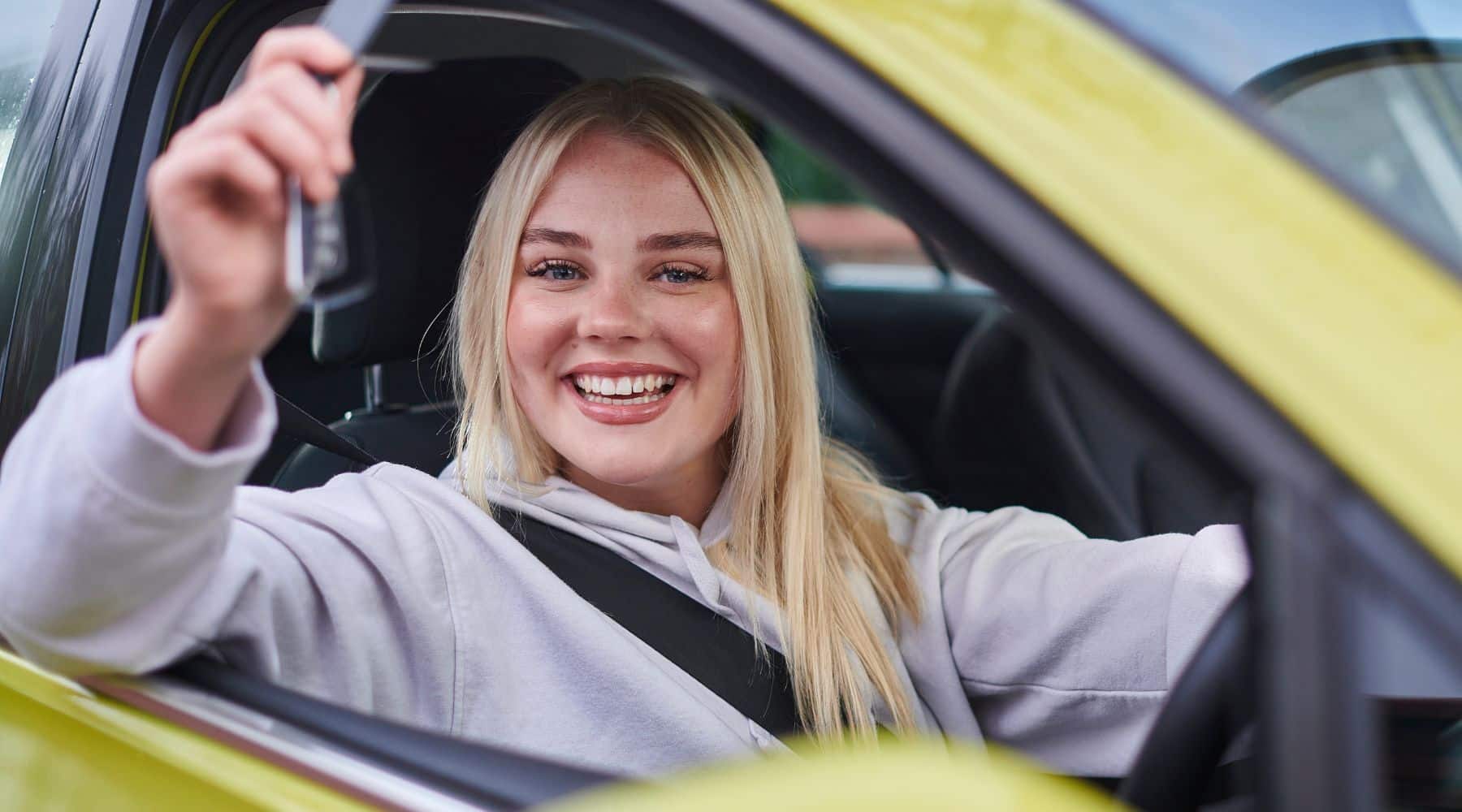 Woman sitting in new car holding the keys