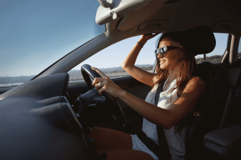 Car Loans Banner - Young woman driving a car in the sunshine