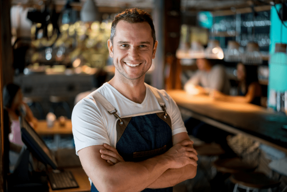 Bartender standing behind the bar wearing an apron
